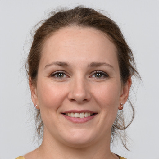 Joyful white young-adult female with medium  brown hair and grey eyes