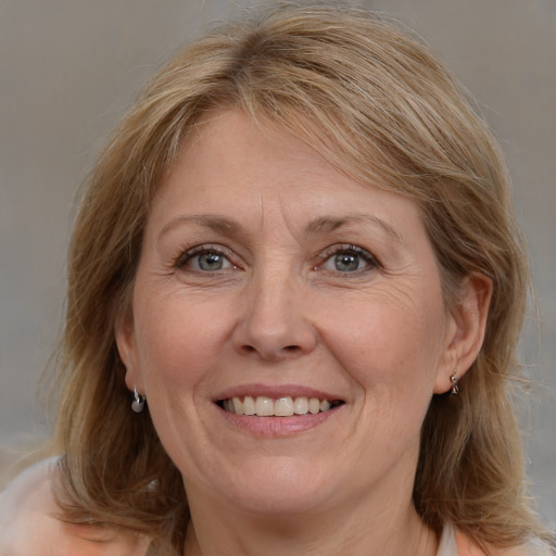 Joyful white adult female with medium  brown hair and grey eyes