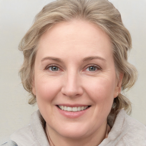 Joyful white adult female with medium  brown hair and blue eyes