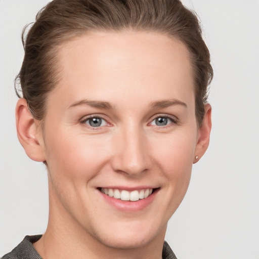 Joyful white young-adult female with short  brown hair and grey eyes