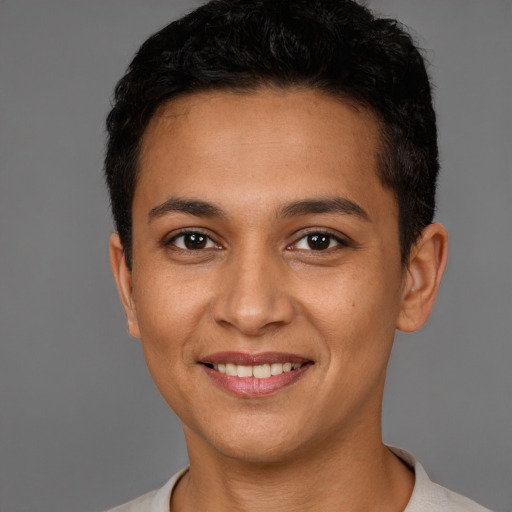 Joyful latino young-adult male with short  brown hair and brown eyes