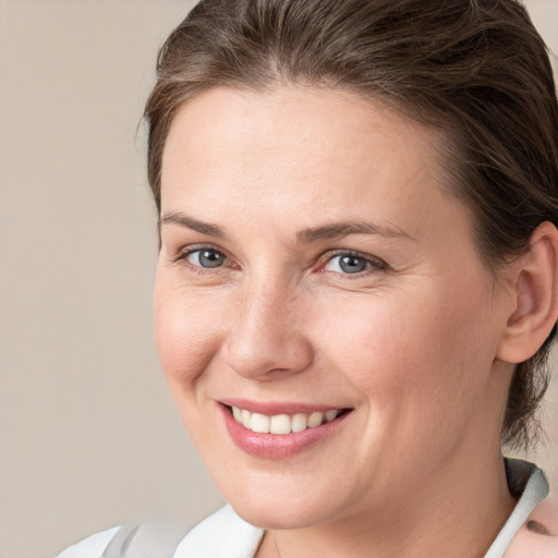 Joyful white young-adult female with medium  brown hair and grey eyes