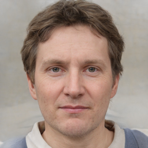 Joyful white adult male with short  brown hair and grey eyes