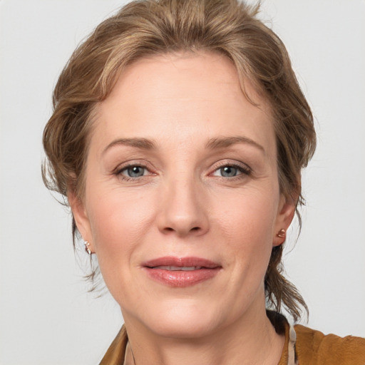 Joyful white adult female with medium  brown hair and grey eyes