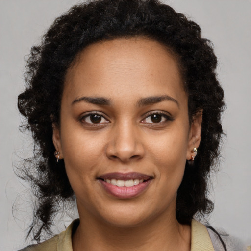 Joyful black young-adult female with long  brown hair and brown eyes