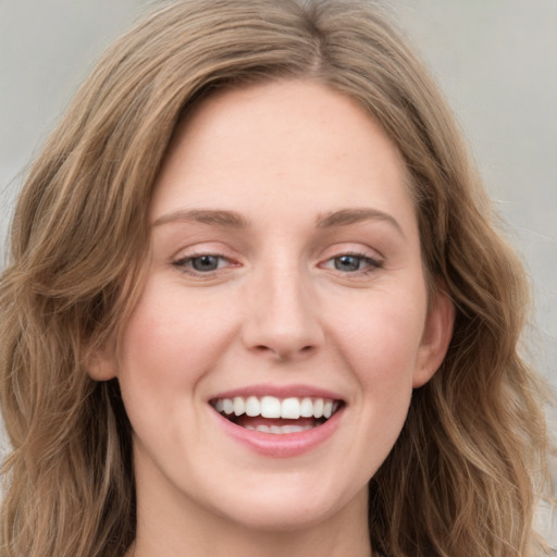 Joyful white young-adult female with long  brown hair and blue eyes