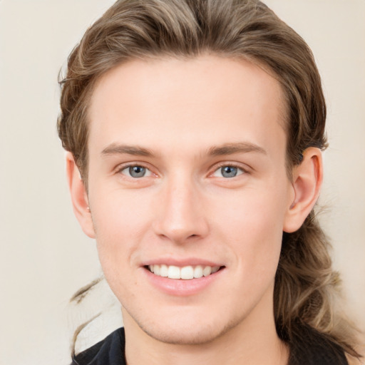 Joyful white young-adult male with medium  brown hair and grey eyes