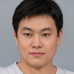 Joyful asian young-adult male with short  brown hair and brown eyes