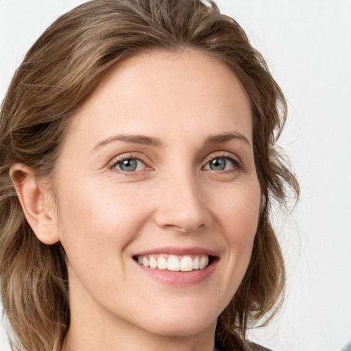 Joyful white young-adult female with medium  brown hair and blue eyes