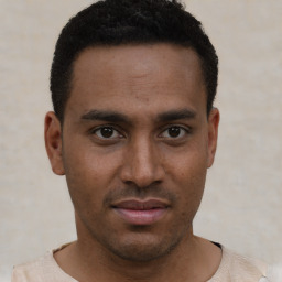 Joyful latino young-adult male with short  brown hair and brown eyes