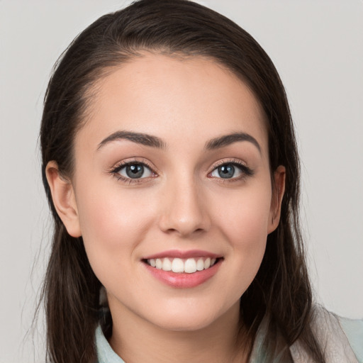 Joyful white young-adult female with long  brown hair and grey eyes