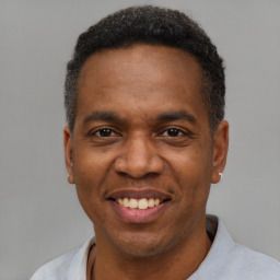 Joyful black adult male with short  black hair and brown eyes