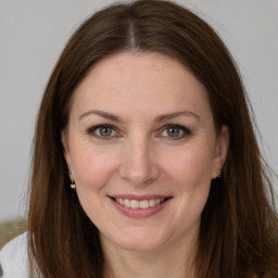 Joyful white adult female with long  brown hair and brown eyes