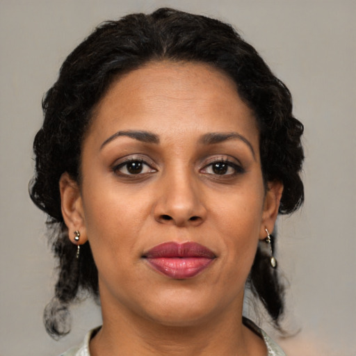 Joyful latino adult female with medium  brown hair and brown eyes