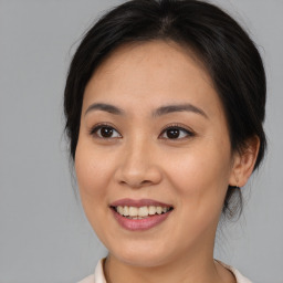 Joyful asian young-adult female with medium  brown hair and brown eyes