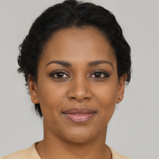 Joyful black young-adult female with short  brown hair and brown eyes