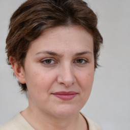 Joyful white young-adult female with medium  brown hair and green eyes