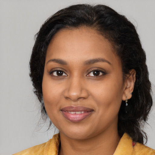 Joyful black young-adult female with long  brown hair and brown eyes