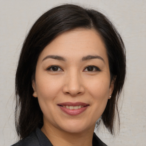 Joyful asian young-adult female with medium  black hair and brown eyes
