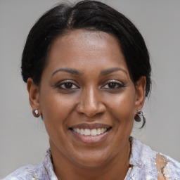 Joyful black adult female with medium  brown hair and brown eyes