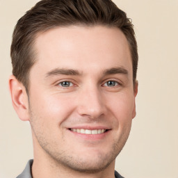 Joyful white young-adult male with short  brown hair and grey eyes