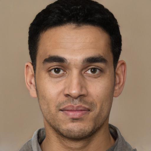 Joyful white young-adult male with short  black hair and brown eyes