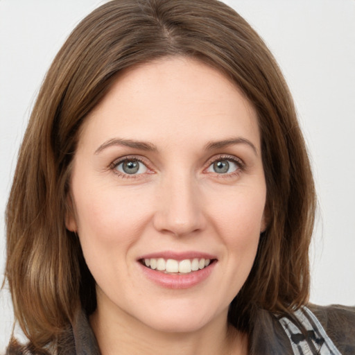 Joyful white young-adult female with medium  brown hair and grey eyes