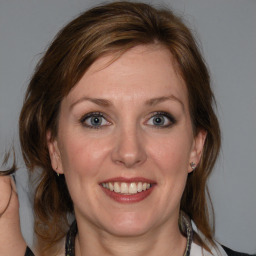 Joyful white adult female with medium  brown hair and blue eyes