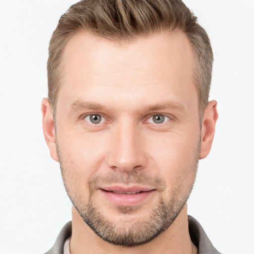 Joyful white young-adult male with short  brown hair and grey eyes