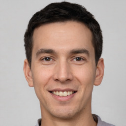 Joyful white young-adult male with short  brown hair and brown eyes