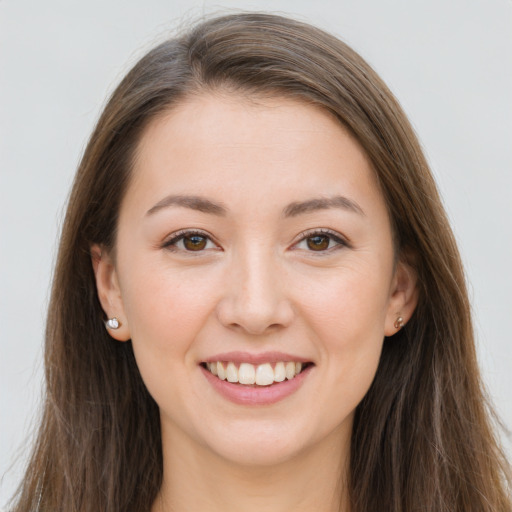 Joyful white young-adult female with long  brown hair and brown eyes