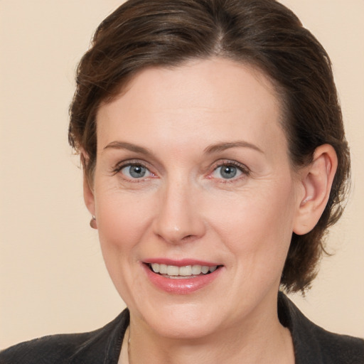 Joyful white adult female with medium  brown hair and grey eyes