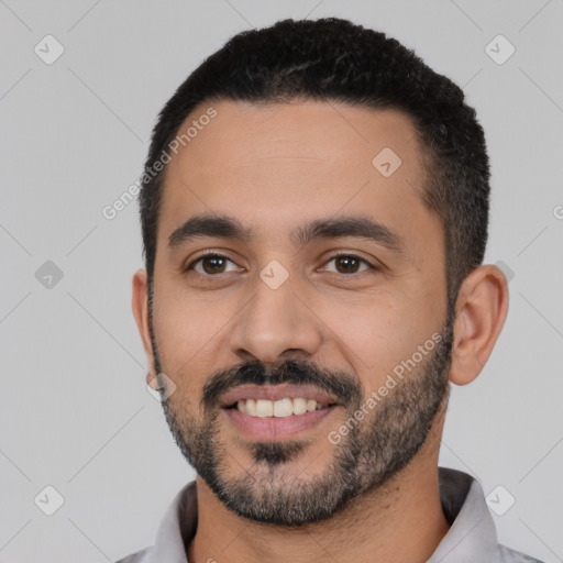 Joyful latino young-adult male with short  black hair and brown eyes