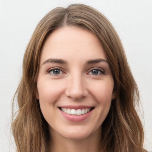 Joyful white young-adult female with long  brown hair and green eyes