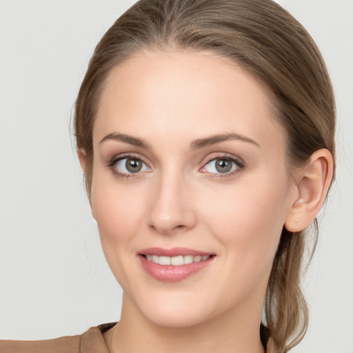 Joyful white young-adult female with medium  brown hair and grey eyes