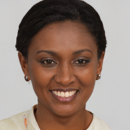 Joyful black young-adult female with short  black hair and brown eyes