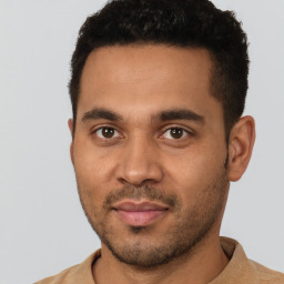 Joyful latino young-adult male with short  brown hair and brown eyes