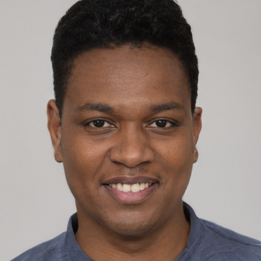 Joyful black young-adult male with short  black hair and brown eyes