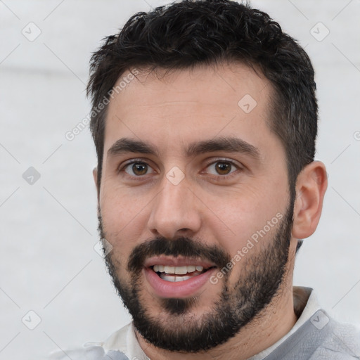 Joyful white young-adult male with short  black hair and brown eyes