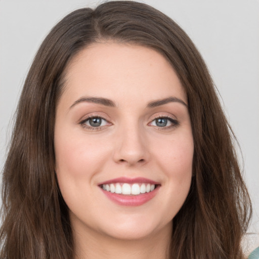 Joyful white young-adult female with long  brown hair and grey eyes