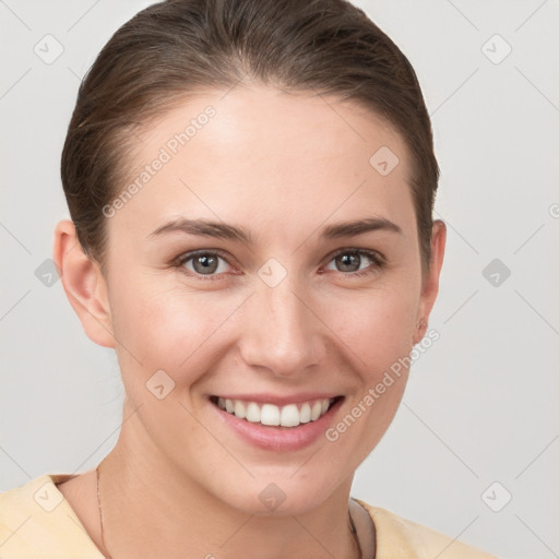 Joyful white young-adult female with medium  brown hair and grey eyes