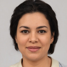 Joyful latino young-adult female with medium  brown hair and brown eyes