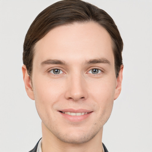 Joyful white young-adult male with short  brown hair and grey eyes