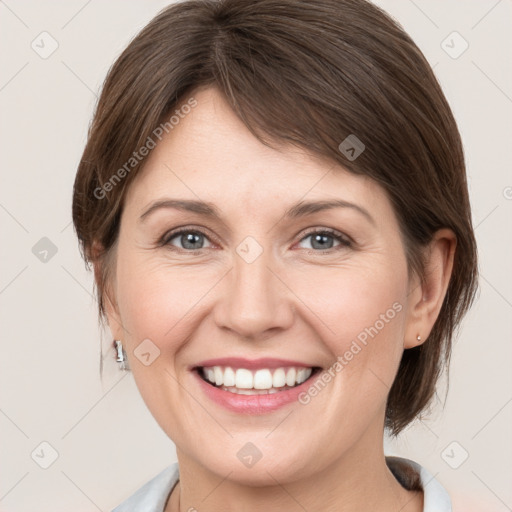 Joyful white young-adult female with medium  brown hair and grey eyes