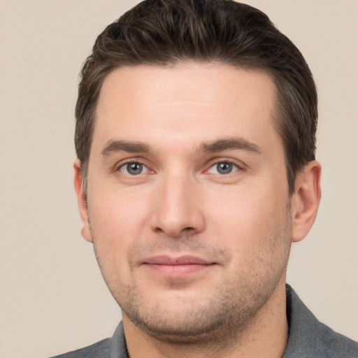 Joyful white young-adult male with short  brown hair and grey eyes