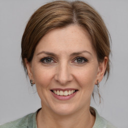 Joyful white adult female with medium  brown hair and grey eyes