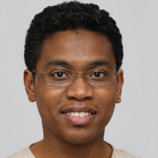 Joyful black young-adult male with short  brown hair and brown eyes