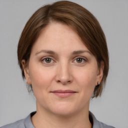 Joyful white young-adult female with medium  brown hair and grey eyes