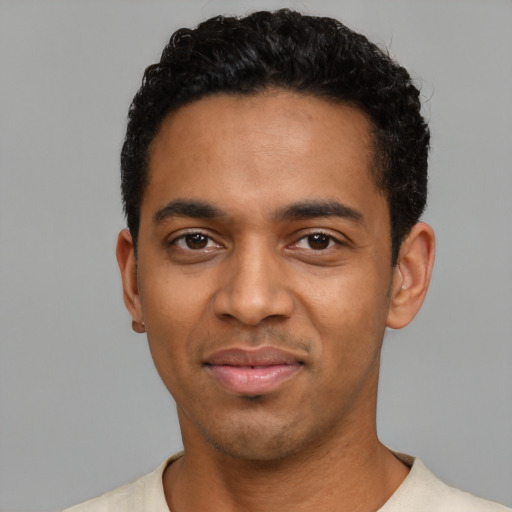 Joyful black young-adult male with short  black hair and brown eyes