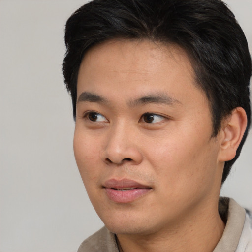 Joyful asian young-adult male with short  brown hair and brown eyes